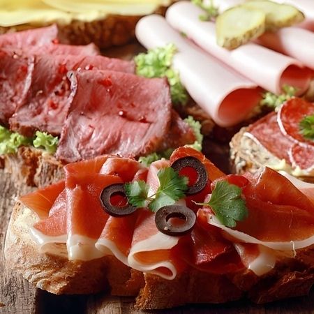 Vielfalt an Fleischspezialitäten auf Brot serviert.
